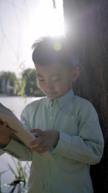 小男孩坐在户外看书